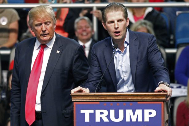Donald J. Trump standing beside Eric Trump as he delivers a speech during a presidential rally.